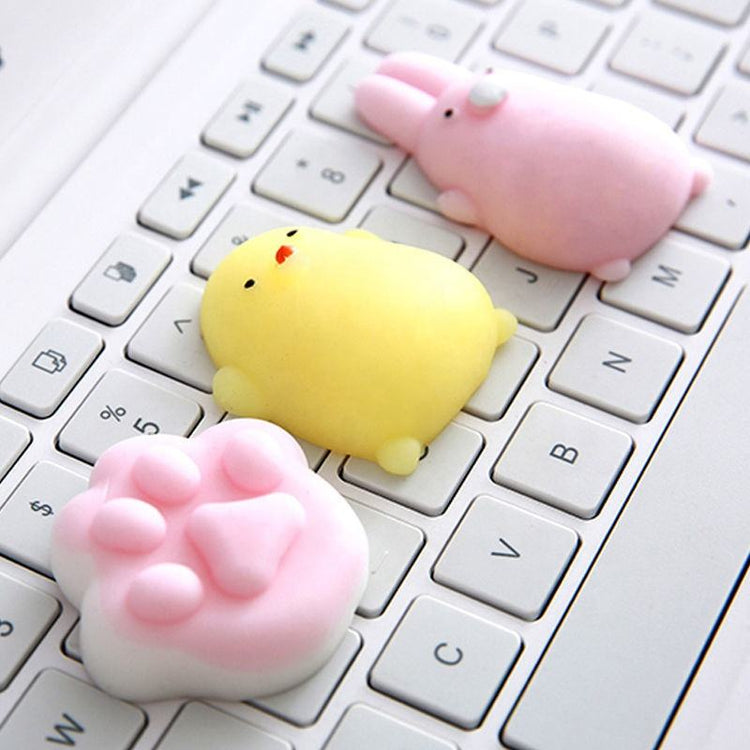Mini squishies shaped like a yellow chick, pink bunny and pink cat paw on a keyboard